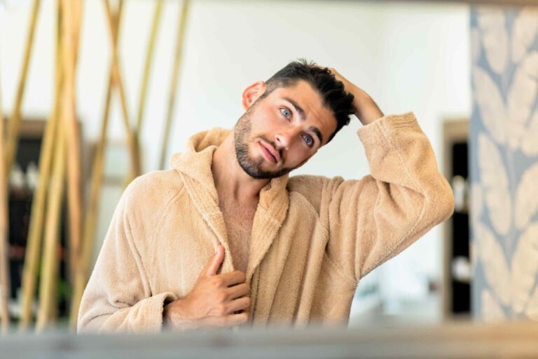 young-man-looking-in-mirror-and-touching-hair
