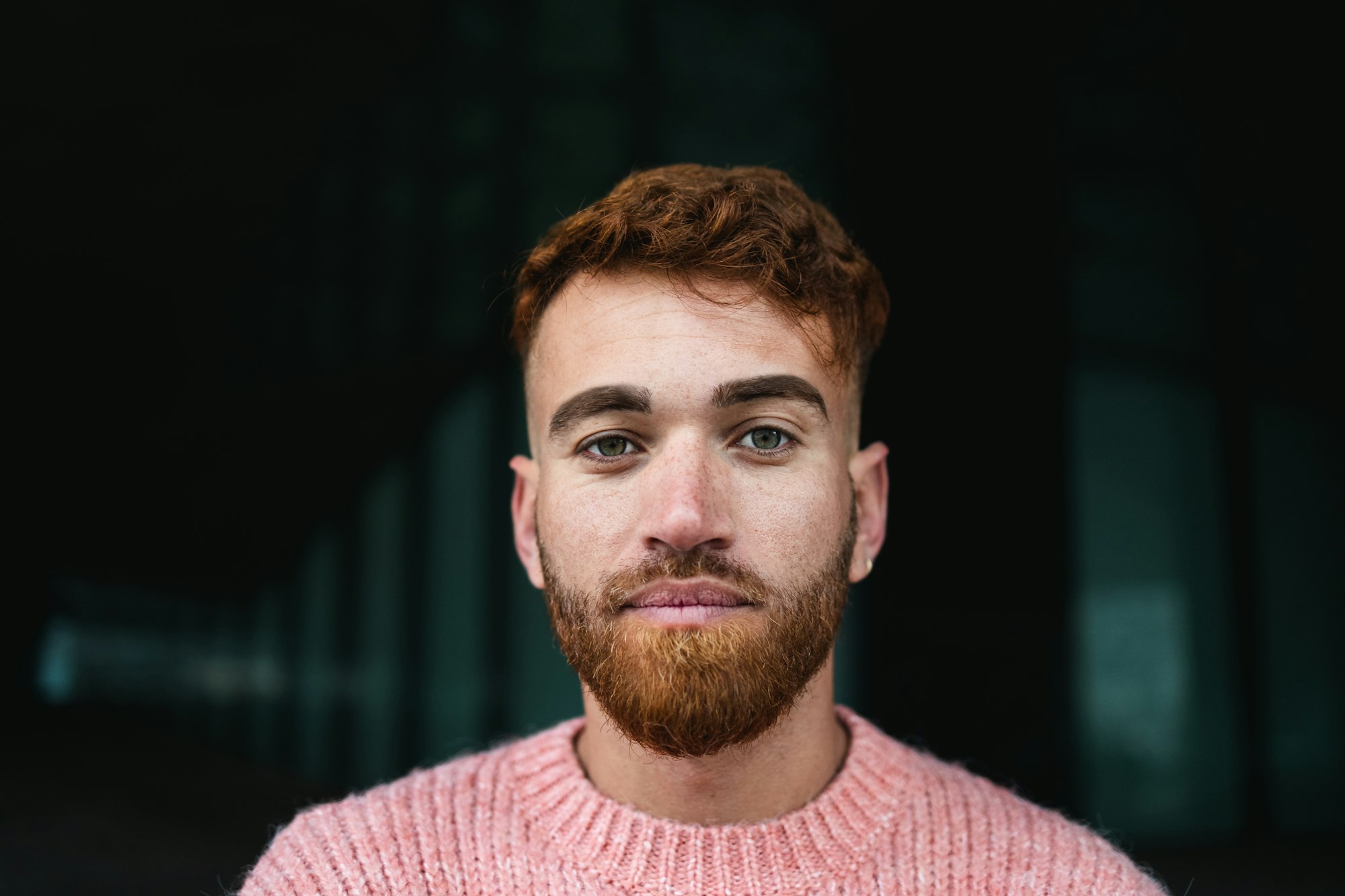 Portrait of young man with red hair looking at the camera