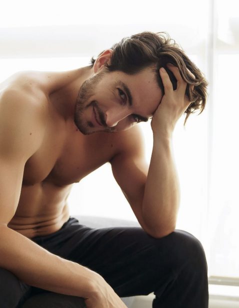 Portrait of young shirtless white man with beautiful hair