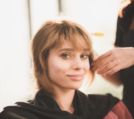 young woman hairdresser in salon, hair care beauty fashion with female girl